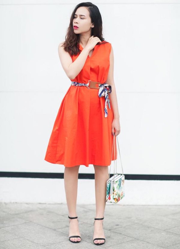 Ca sĩ Lưu Hương Giang thanh lịch trong chiếc váy sơ mi màu sáng tông màu cam mix cùng phụ kiện túi xách in hoa nữ tính, hài hòa